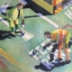 men painting road markings using anagrams
